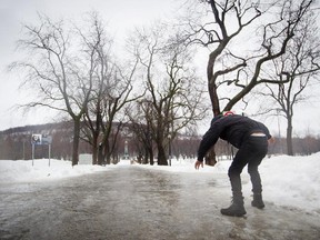 A man tries to regain his balance as he walks on an icy walkway in January 2014.
