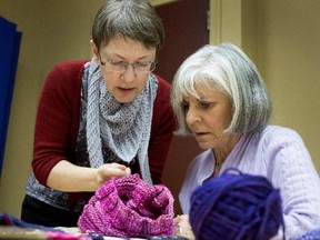 Odette Ferland, left, helps Frances Kalil, who is part of a group of women who meet every Monday to knit in the Town of Mount Royal.