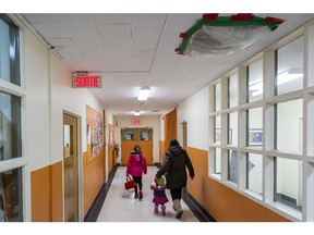 MONTREAL, QUE.: NOVEMBER 20, 2014 -- A parent arrives with children for a public meeting at the Sainte-Catherine-de-Sienne school in the borough of Notre-Dame-de-Gr¾¢ce in Montreal on Thursday, November 20, 2014. The school, which is part of the Commission scolaire de Montr¾©al school board, will have to close for renovations. (Dario Ayala / Montreal Gazette)