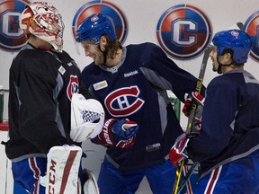 Canadiens defenceman Tom Gilbert, centre, jokes with goalie Carey Price and Mike Weaver during a break in practice at the Bell Sports Complex  in Brossard on Nov. 27, 2014.