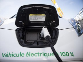 A 2012 Nissan Leaf with an electric power cord sits in the parking lot during a test drive session for the the EV 2012 Electric Vehicle trade show at the Circuit Gilles Villeneuve in Montreal on Tuesday, October 23, 2012.