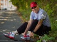 Carl Andersen ties his shoes prior to going for a run along the de Maisonneuve bike path in the Notre-Dame-de-Grace district in Montreal Sunday September 07, 2014.