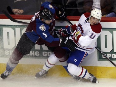 Colorado Avalanche defenceman Nate Guenin, left, checks Montreal Canadiens right wing Brendan Gallagher along the boards in the second period of an NHL hockey game in Denver on Monday, Dec. 1, 2014.