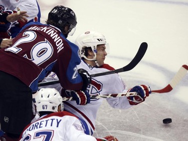 Montreal Canadiens centre David Desharnais, back, falls backward onto ice as he battles for control of the puck with Colorado Avalanche centre Nathan MacKinnon in the second period of an NHL hockey game in Denver on Monday, Dec. 1, 2014.