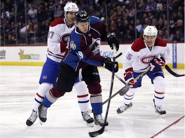 Colorado Avalanche centre Nathan MacKinnon, front left, takes shot as Montreal Canadiens left wing Max Pacioretty, back left, and right wing Pierre-Alexandre Parenteau defend, in the first period of an NHL hockey game in Denver on Monday, Dec. 1, 2014.