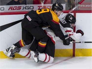 Team Canada's Josh Morrissey is checked from behind by Team Germany's Nico Sturm during second period preliminary round hockey action at the IIHF World Junior Championship Saturday, December 27, 2014 in Montreal.