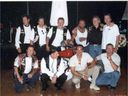 Das Nomadenkapitel in glücklicheren Zeiten.  - Ein Gruppenfoto, das aufgenommen wurde, als sie am 5. August 2000 die Hochzeit von Hells Angel René Charlébois feierten, nur wenige Monate bevor die Operation Springtime 2001 durchgeführt wurde.  Von links nach rechts oben: Michel Rose (zu 22 Jahren verurteilt), Donald (Pup) Stockford (zu 20 Jahren verurteilt), Gilles (Trooper) Mathieu (zu 20 Jahren verurteilt), Richard (Dick) Mayrand (zu 22 Jahren verurteilt) , Denis Houle (zu 20 Jahren verurteilt), David (Wolf) Carroll (bei Operation Springtime 2001 noch nicht festgenommen).  Von links nach rechts unten: Walter (Nurget) Stadnick (zu 20 Jahren verurteilt), René Charlébois (zu 20 Jahren verurteilt), Normand Robitaille (zu 21 Jahren verurteilt), Maurice (Mutter) Boucher (zu lebenslanger Haft verurteilt wegen Anordnung der Tod von zwei Gefängniswärtern).  