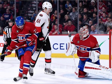 Carey Price of the Montreal Canadiens stops the puck in front of teammate Tom Gilbert and Mark Stone  of the Ottawa Senators during the NHL game at the Bell Centre on December 20, 2014, in Montreal.