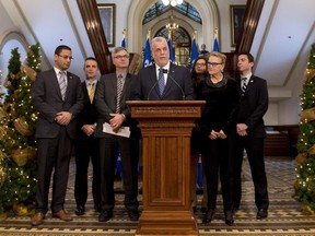 Quebec Premier Philippe Couillard, flanked by members of the government, speaks at a news conference marking the end of the fall session Friday, December 5, 2014 at the legislature in Quebec City.