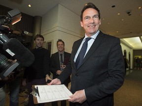 Pierre Karl Peladeau holds up his nomination papers to run for the leadership of the Parti Quebecois in Montreal, Thursday, November 27, 2014.