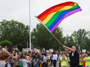 Principal Pete Cahall waves a rainbow flag at a rally of about 1,000 Woodrow Wilson High School students and supporters June 9, 2014, at Woodrow Wilson High School in Washington, DC. The rally was held to counter a planned protest by  Westboro Baptist Church, the Kansas-based organization known for anti-gay picketing.