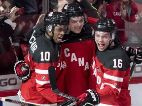 Team Canada's Sam Reinhart, centre, is congratulated by teammates Anthony Duclair, left, and Max Domi after scoting past Team Finland goaltender Juuse Saros during first period preliminary round hockey action at the IIHF World Junior Championship Monday, December 29, 2014, in Montreal.