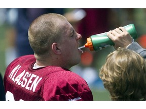 SHERBROOKE, QUE.: JUNE 1, 2014 --  Montreal Alouettes defensive lineman Michael Klassen gets a drink of water from a team staffer during the first day of the team's training camp, at Bishops University in Sherbrooke, east of Montreal, Sunday, June 1, 2014.  (Phil Carpenter / THE GAZETTE)  ORG XMIT: 50105