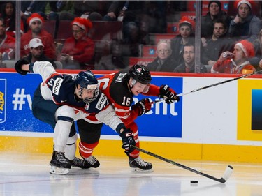 MONTREAL, QC - DECEMBER 26:  Erik Cernak #14 of Team Slovakia and Max Domi #16 of Team Canada chase the puck during the 2015 IIHF World Junior Hockey Championship game at the Bell Centre on December 26, 2014 in Montreal, Quebec, Canada.  Team Canada defeated Team Slovakia 8-0.