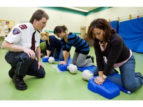 Paramedic instructor Patrice Ruest watches as Naouel Magherbi, a teacher at Cavalier LaSalle High School performs chest compressions during a CPR class.