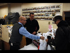 Tommy Kulczyk, Sun Youth’s assistant executive vice-president (left), and Stéphane Le Gal, Montreal Gazette’s
regional vice-president of advertising sales (second from left), help with the distribution of holiday baskets last year.