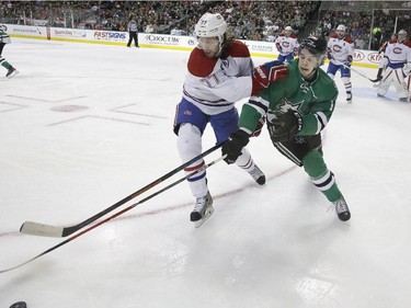 Montreal Canadiens defenceman Tom Gilbert (77) and Dallas Stars left wing Curtis McKenzie (11) skate for the loose puck during the first period of an NHL hockey game Saturday, Dec. 6, 2014, in Dallas.