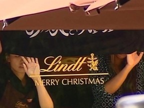 Screengrab taken from the Australian Channel Seven broadcast shows presumed hostages holding up a flag with Arabic writing inside a café in the central business district of Sydney Dec. 15, 2014.