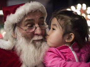 A girl kisses a Santa Claus at the Intercontinental hotel of Beijing, on December,19, 2014.