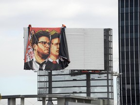 Workers remove a poster-banner for The Interview from a billboard in Hollywood, California, December 18, 2014 a day after Sony announced it had no choice but to cancel the movie's Christmas release and pull it from theatres due to a credible threat.  Sony defended itself Thursday against a flood of criticism for canceling the movie which angered North Korea and triggered a massive cyber-attack, as the crisis took a wider diplomatic turn.