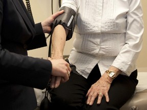 A doctor prepares to check the blood pressure of a recent elderly stroke patient  at the University of Calgary Foothills Campus on Friday, February 24, 2012.
