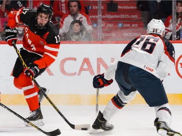 Connor McDavid #17 of Team Canada looks to shoot the puck near Brandon Carlo #26 of Team United States during the 2015 IIHF World Junior Hockey Championship game at the Bell Centre on December 31, 2014 in Montreal, Quebec, Canada.