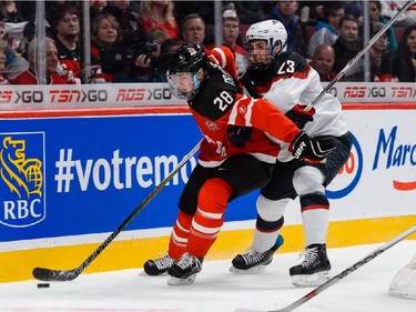 Zach Werenski #23 of Team United States challenges Lawson Crouse #28 of Team Canada near the boards during the 2015 IIHF World Junior Hockey Championship game at the Bell Centre on December 31, 2014 in Montreal, Quebec, Canada.