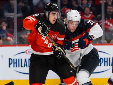Robby Fabbri #29 of Team Canada and Hudson Fasching #22 of Team United States check one another during the 2015 IIHF World Junior Hockey Championship game at the Bell Centre on December 31, 2014 in Montreal, Quebec, Canada.
