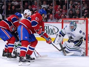 Max Pacioretty (#67) of the Montreal Canadiens shoots the puck on Ryan Miller (#30) of the Vancouver Canucks during the NHL game at the Bell Centre on December 9, 2014 in Montreal, Quebec, Canada.