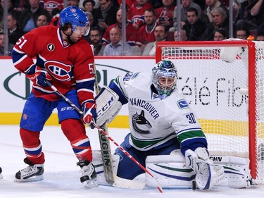 Ryan Miller (#30) of the Vancouver Canucks stops the puck in front of David Desharnais (#51) of the Montreal Canadiens during the NHL game at the Bell Centre on December 9, 2014 in Montreal, Quebec, Canada.