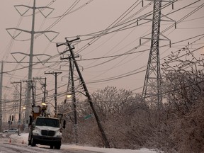 Hydro crews wait for backup to replace a damaged pole on Champlain Blvd. in Montreal on Sunday January 4, 2015. (Allen McInnis / MONTREAL GAZETTE)