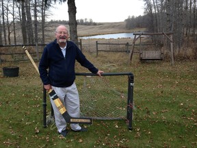 NHL goaltending great Glenn Hall stands in front of a children's plastic goal net holding a stick he used in the 1962-63 NHL All-Star Game, photographed on Hall's 155-acre farm in Stony Plain, Alta., on Oct. 26, 2014.