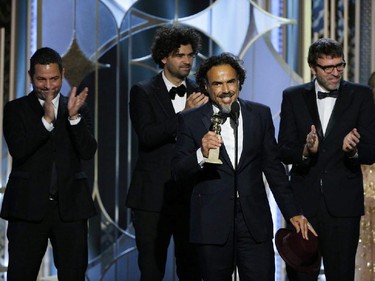 In this image released by NBC, Alejandro Gonzalez Inarritu, accepts the award for best screenplay for "Birdman,"with Alexander Dinelaris, background from left, Armando Bo, and Nicolas Giacobone at the 72nd Annual Golden Globe Awards on Sunday, Jan. 11, 2015, at the Beverly Hilton Hotel in Beverly Hills, Calif.