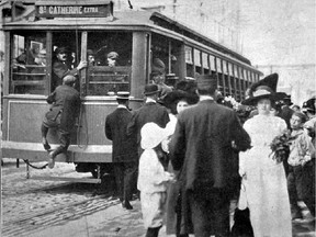 A boy hangs onto a streetcar in Montreal in 1912.