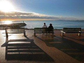 A couple look out towards the Mediterranean sea at Cagnes sur Mer, near Nice, southeastern France, Sunday, Dec. 7, 2014. The temperature rose to 18 degrees cels ius (64 fahrenheit).