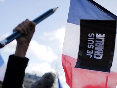 A demonstrator holds up an oversized pencil at Republique Square, Paris, before the start of a demonstration, Sunday, Jan. 11, 2015. A rally of defiance and sorrow, protected by an unparalleled level of security, on Sunday will honor the 17 victims of three days of bloodshed in Paris that left France on alert for more violence.