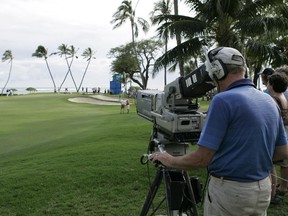 A television cameraman shoots golfers on the 16th green during the second round of the Sony Open golf tournament, Friday, Jan, 16, 2015, in Honolulu.