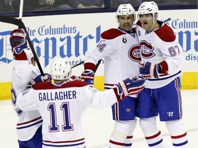 Montreal Canadiens' Andrei Markov (79), of Russia, Brendan Gallagher (11), Tomas Plekanec (14) , of the Czech Republic, and Max Pacioretty (67) celebrate Pacioretty's second goal against the Columbus Blue Jackets during the third period of an NHL hockey game in Columbus, Ohio, Wednesday, Jan. 14, 2015. Montreal won 3-2.