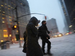 Pedestrians walk along a Manhattan street in heavy snow on January 26, 2015 in New York City. New York and much of the Northeast is bracing for a major winter storm which is expected to bring blizzard conditions and 18 to 24 inches of snow to the area. New York City Mayor Bill de Blasio has announced that only emergency vehicles will be allowed on area roads after 11 p.m.