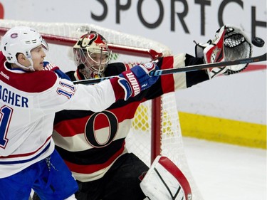 Montreal Canadiens right wing Brendan Gallagher swings at the puck as Ottawa Senators goalie Craig Anderson reaches with his glove during first-period NHL action Thursday, Jan. 15, 2015, in Ottawa.