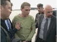 This file photograph courtesy of Montreal police shows Luka  Magnotta escorted by police upon arrival from Germany on June 18, 2012 at Mirabel Airport.