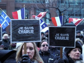 Women hold placards reading, Je Suis Charlie (I am Charlie) during a solidarity rally on January 11, 2015 in Montreal to honor the 17 victims of a three-day killing spree by homegrown Islamists. About 25,000 people marched Sunday in Montreal in solidarity with France and in memory of 17 people killed in jihadist attacks in Paris, organizers said. Montreal Mayor Denis Coderre and several Quebec officials joined the French consul general Bruno Clerc at the head of a long procession by marchers waving Canadian, French and Quebecois flags, as well as signs bearing the message "Je Suis Charlie.