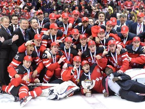 Canadian players and officials pose with the trophy as they celebrate their 5-4 win over Russia during the gold medal game hockey action at the IIHF World Junior Championship in Toronto on Monday, Jan. 5, 2015.