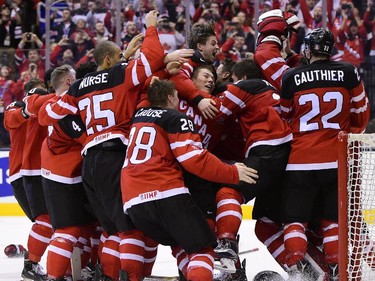 Canadian players celebrate Canada's 5-4 win over Russia during the gold medal game hockey action at the IIHF World Junior Championship in Toronto on Monday, Jan. 5, 2015.