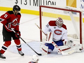 Canadiens goalie Carey Price makes a save as New Jersey Devils' Martin Havlat of the Czech Republic, watches during the third period of an NHL hockey game, Friday, Jan. 2, 2015, in Newark, N.J. The Canadiens won 4-2.