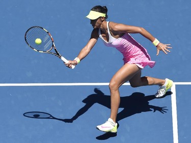 Caroline Garcia of France makes a forehand return to Eugenie Bouchard of Canada during their third round match at the Australian Open tennis championship in Melbourne, Australia, Friday, Jan. 23, 2015.