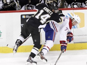 Pittsburgh Penguins' Chris Kunitz (14) checks Montreal Canadiens' Tom Gilbert (77) during the first period of an NHL hockey game in Pittsburgh, Saturday, Jan. 3, 2015.