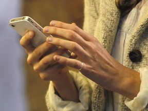 A woman uses her smartphone in central London, Wednesday, Nov. 14, 2012.