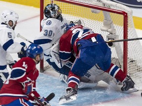 Montreal Canadiens' Dale Weise falls onto Tampa Bay Lightning goalie Ben Bishop during second period NHL hockey action Tuesday, January 6, 2015 in Montreal.