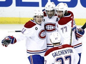 Montreal Canadiens' Max Pacioretty, center, is congratulated by Brendan Gallagher (11) and Tom Gilbert (77) after scoring a goal against the Pittsburgh Penguins during the first period of an NHL hockey game in Pittsburgh, Saturday, Jan. 3, 2015.